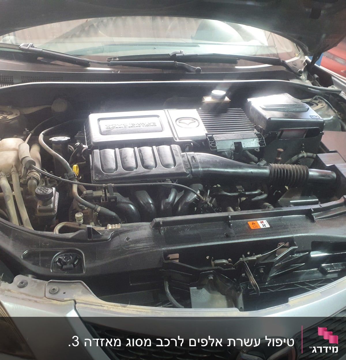 מנוע רכב עם מכסה פתוח, צינורות ומיכלים גלויים